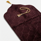 Brown prayer mat with a tassel on a light gray background