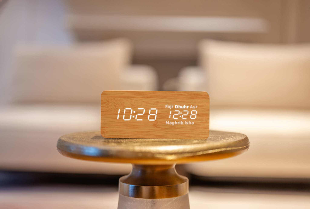 Beige smart athan clock on gold table showing dhuhr as next prayer time